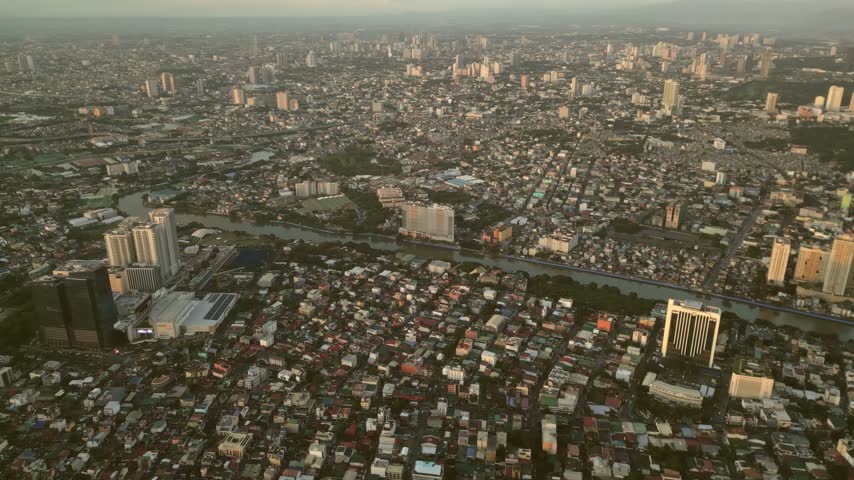 Aerial view of the dense urban sprawl of Manila featuring high-rise buildings, residential rooftops, and the winding Pasig River flowing through the city, Manila, Metro Manila, Philippines.