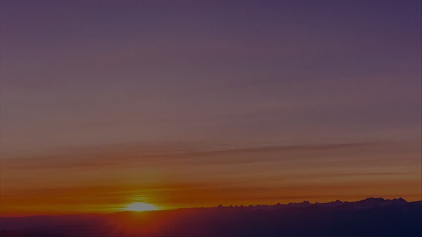 Dramatic Orange Sunset Over Mountain Silhouette with Colorful Purple Sky and Glowing Horizon