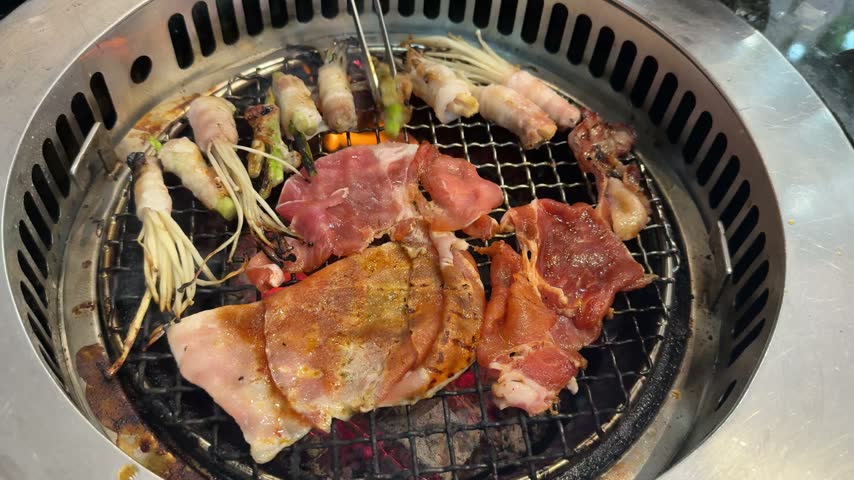 Fresh prawns, bacon-wrapped enoki mushrooms, and bacon-wrapped asparagus grilling over hot charcoal