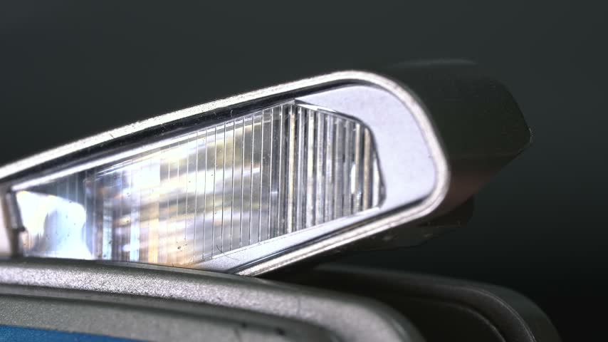 The pop-up flash mechanism in action on an old film camera from the 1990s.