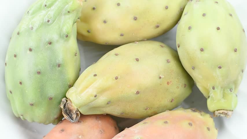 Prickly pears on a white plate, second flower variety from Catania, Sicily, Italy. Extreme close-up, rotating video.