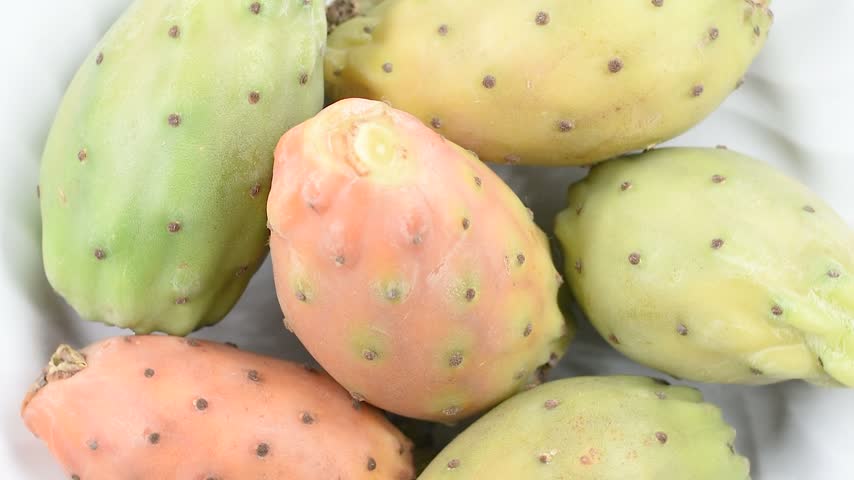 Prickly pears on a white plate, second flower variety from Catania, Sicily, Italy. Extreme close-up, rotating video.