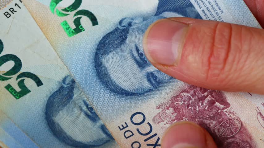 Mexico money. Macro close-up of mexican peso being counted by hand. Paper banknotes of 500 and 1000 pesos. MXN currency symbol. Financial and business concept