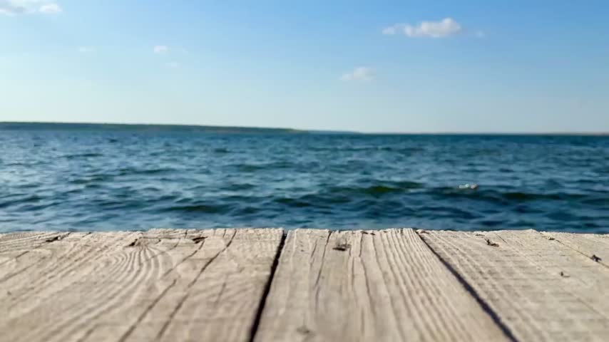 View of wavy water and wooden pier in bay, selective focus