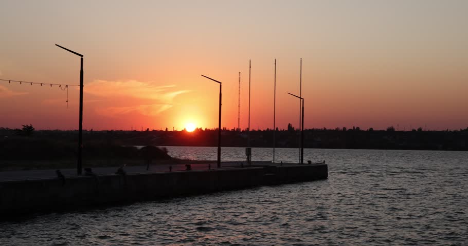 Beautiful river and pier at sunset, camera moving right