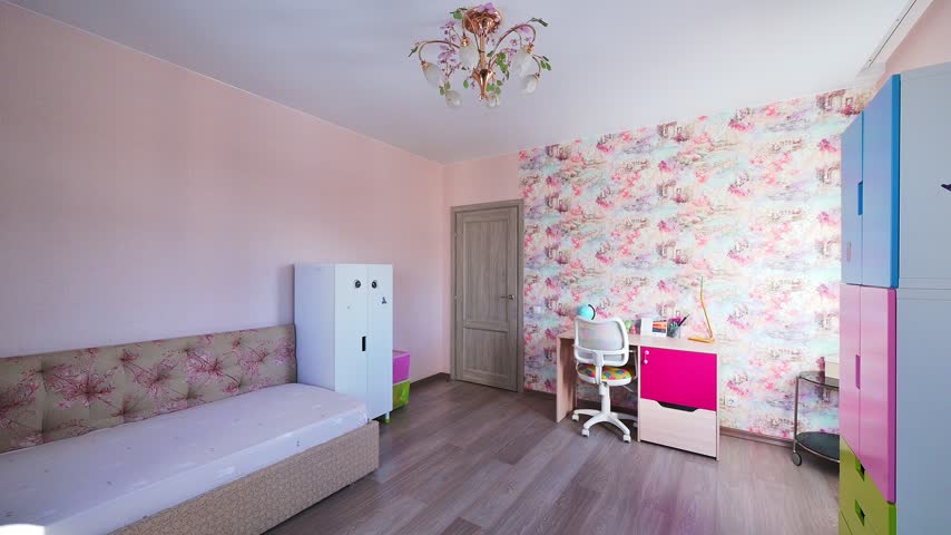 Cozy child’s room with floral wallpaper, pastel furniture, built‑in bed, study desk, colorful storage, vintage‑style chandelier.

