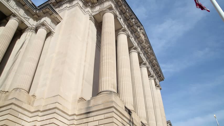 Camera tilts down fluted columns along a classical facade in Washington DC.
