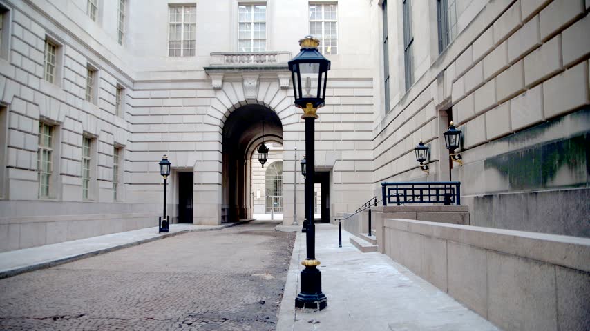 Street lamps line a courtyard walkway leading toward an archway in Washington.