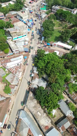 Aerial view of a busy small town street with local markets and buildings an perspective looking down at a road bustling with activity