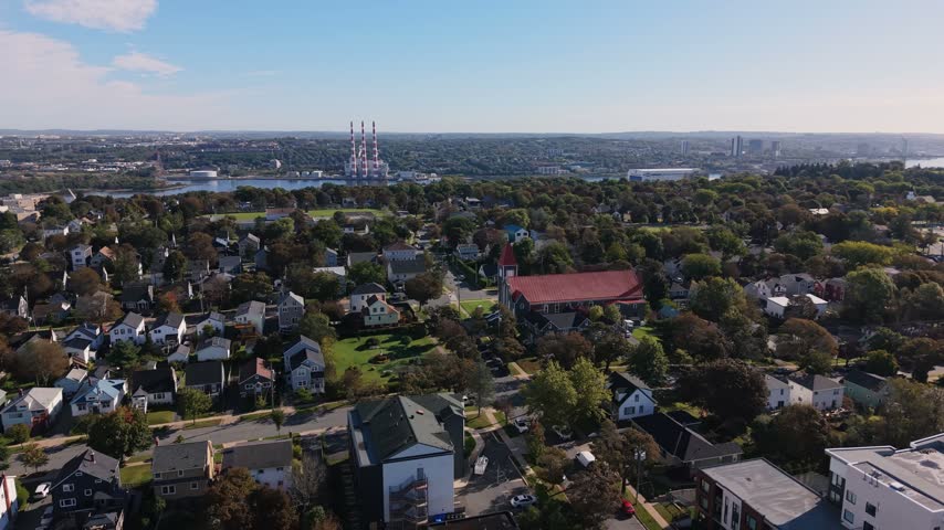Experience a stunning aerial perspective of Halifax, Nova Scotia, where urban life meets serene greenery. The vibrant cityscape reveals beautiful homes surrounded by lush landscapes.