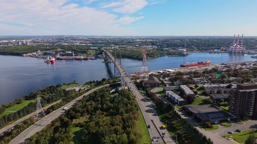 Experience the stunning aerial views of Halifax, Nova Scotia, with expansive views of the city, lush greenery, and the bustling harbor filled with ships.