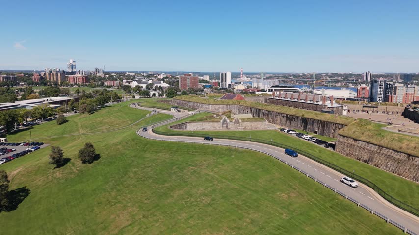 Enjoy a sweeping aerial view of Halifax, Nova Scotia, showcasing its vibrant cityscape and lush green spaces. The scenery reveals a blend of modern buildings and natural beauty.