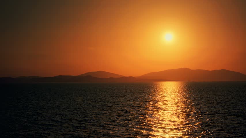 Sunset Over Ocean With Mountain Silhouettes at Dusk