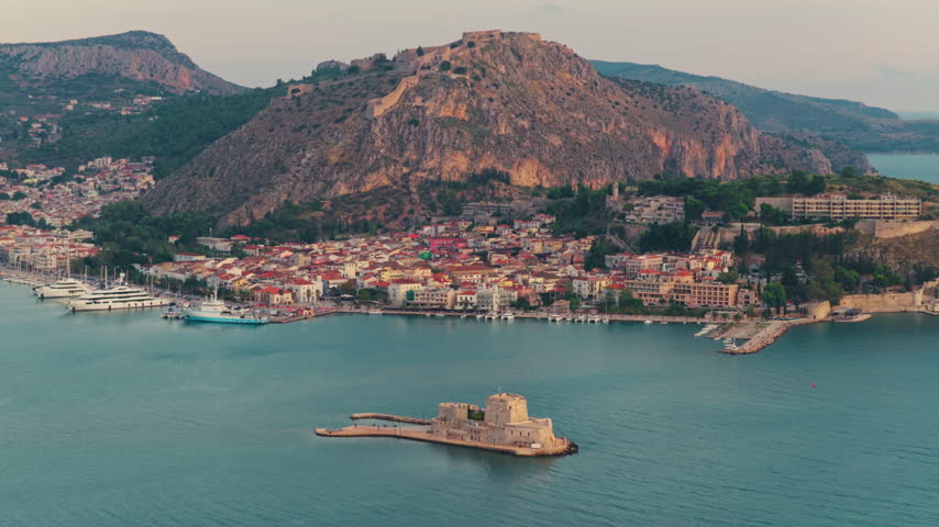 Beautiful aerial perspective of the historic city of Nafplio in Greece, showing the iconic Bourtzi water castle in the Argolic Gulf and the impressive Palamidi fortress perched on the hilltop
