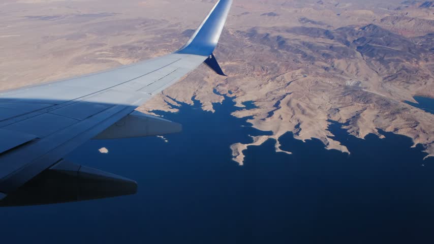 Airplane wing flying over lake mead and hoover dam