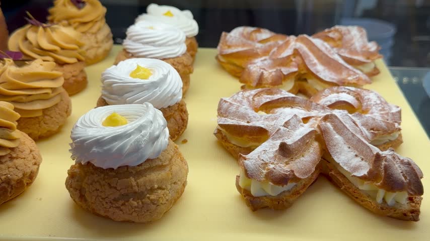 Assorted fresh pastries stand on tray inside bakery display cafe. Sweet delicious desserts offer artisan baking theme, coffee shop showcase, restaurant pastry collection and sugary food retail.