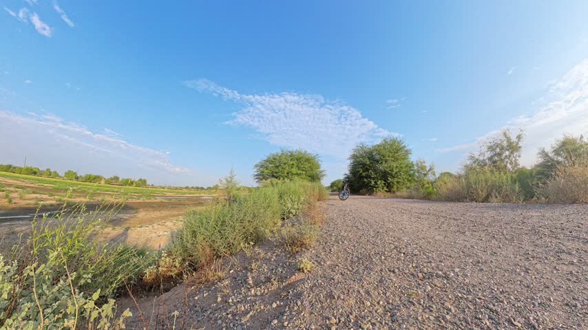 Gravel Trail Beside Wetland Basin Under Blue Sky