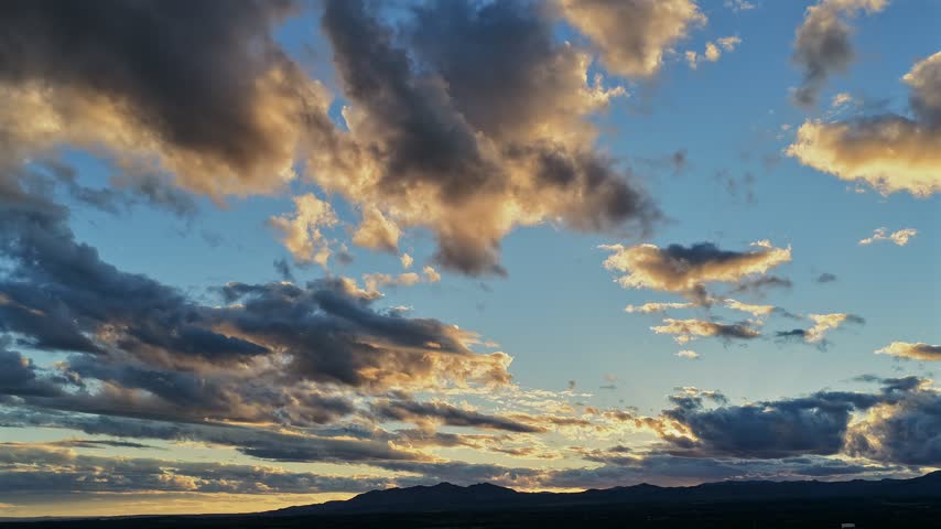 Aerial view of dramatic clouds and golden sunset light over the southwestern landscape in Los Alamos, New Mexico, United States.