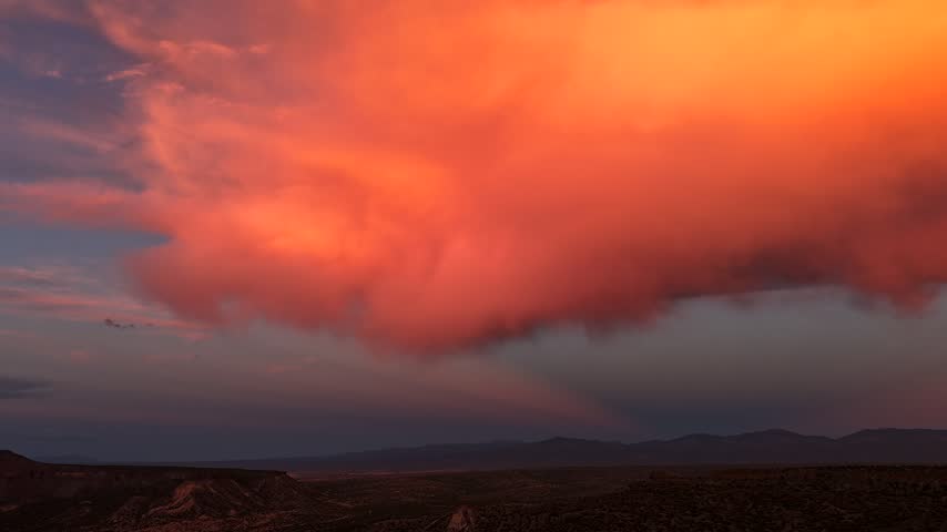 Aerial view of vibrant sunset clouds illuminating the mountain landscape with warm light in White Rock, New Mexico, United States.