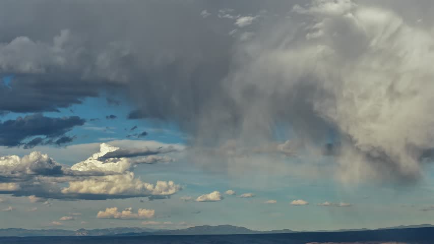 Aerial view of dramatic storm clouds and rainfall drifting over the landscape in White Rock, New Mexico, United States.