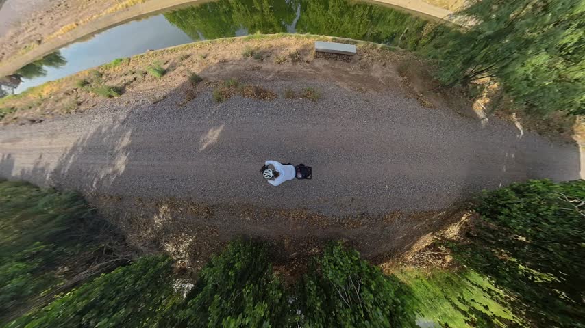 Overhead View of Cyclist Riding Across Bridge Over Canal