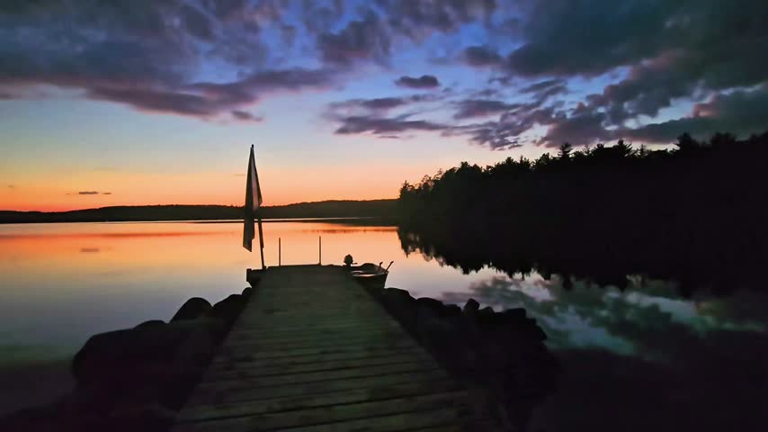 Sunset across calm tranquil lake view from dock