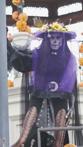 Catrina wearing purple veil at decorated Mexican gazebo.