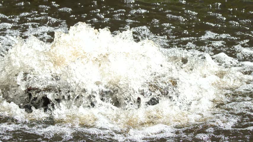 Close up of bubbling water splashing and foaming from an outdoor pond aeration fountain.