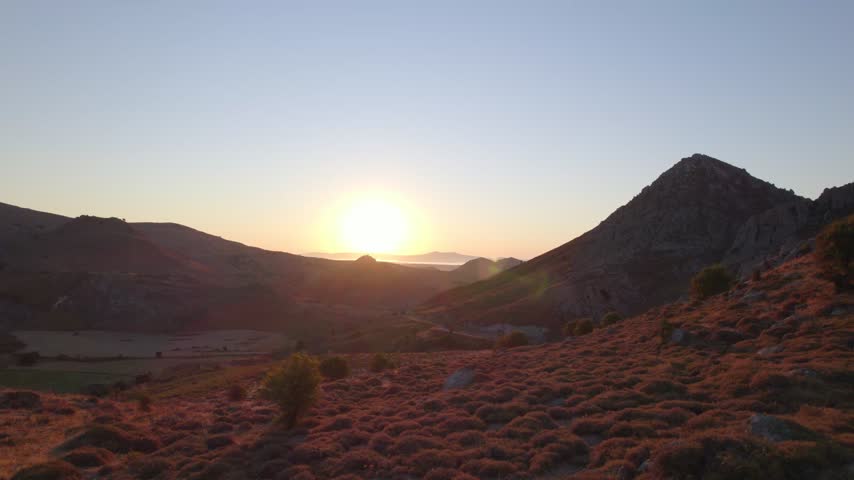 Sunrise over the mountainous landscape of Lemnos, Greece, as warm morning light illuminates the hills.