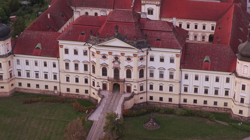 Aerial view of the historic Hradisko Monastery featuring red tiled roofs and white baroque architecture in Olomouc, Olomouc Region, Czechia.