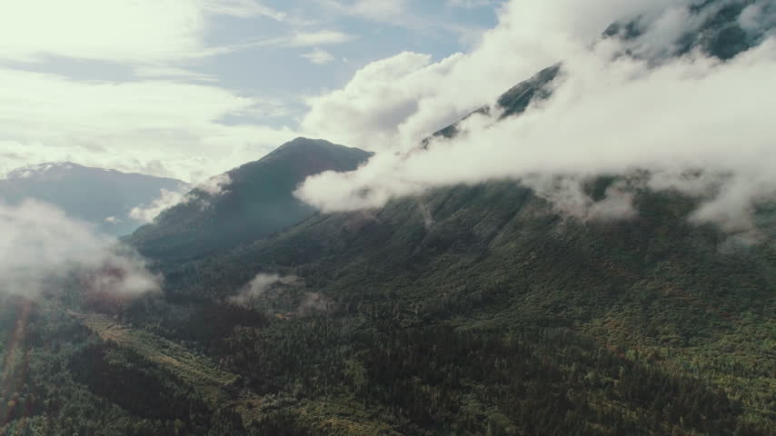 Clouds clinging to a forested mountain in Alaska aerial