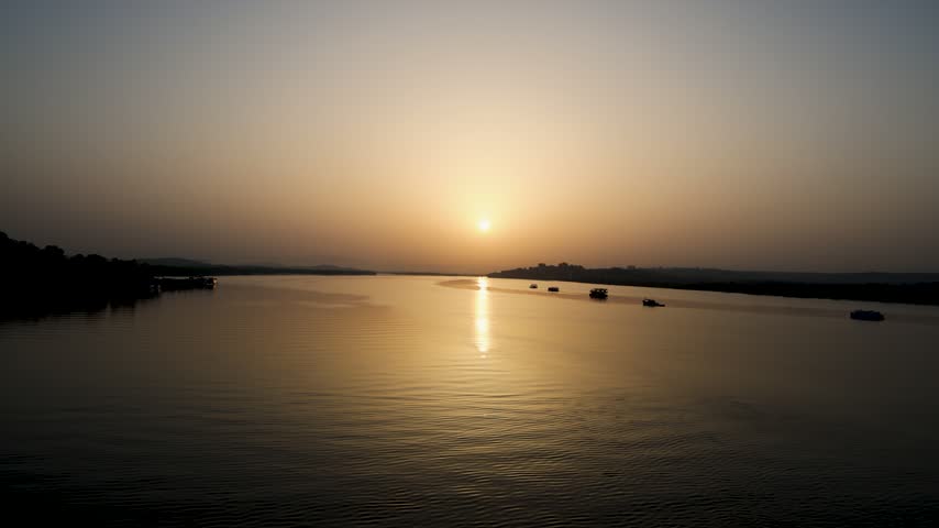 Golden Sunset Over Wide River With Boats And Calm Water