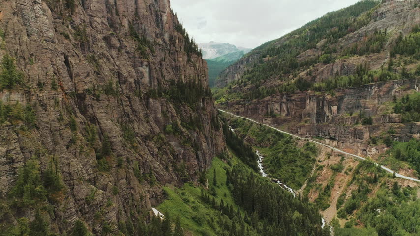 Mountain highway on cliffs above a gorge river aerial