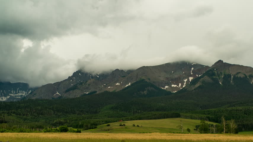 Storm clouds rolling over rugged mountain peaks in Colorado timelapse