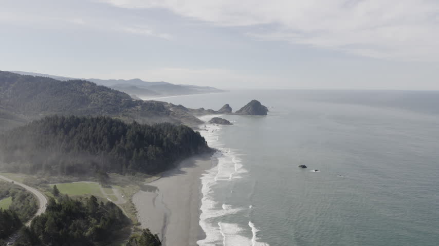 Arizona beach at the Southern Oregon Coast on a hazy day, drone flyover.