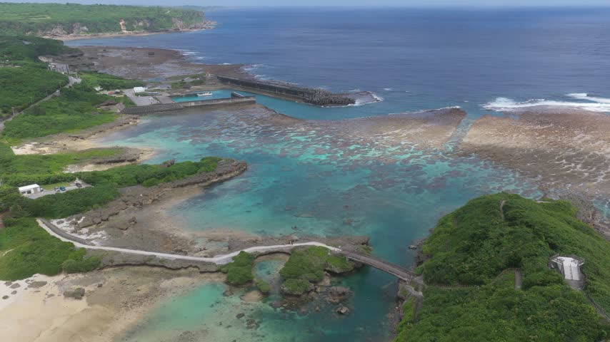 Imgya Marine Garden on Miyakojima, Okinawa, Japan, features sheltered turquoise waters, rocky coastal formations and scenic ocean views near Ingya Bridge - drone shot