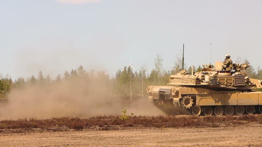 American Main Battle Tank Driving Through Dusty Field Environment During Intensive Military Training Operations In Desert.