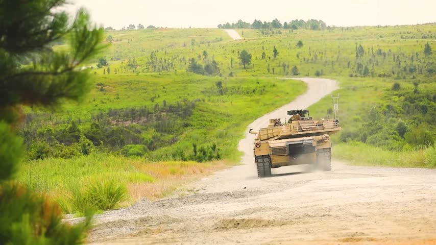 Military Main Battle Tank Firing Heavy Cannon On Dirt Road Creating Huge Fireball During Live Fire Exercises.