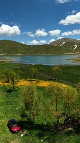 Landscape view of a lake with green grass, trees, and hills under a cloudy blue sky — Taurus Mountains, Antalya, Alanya
