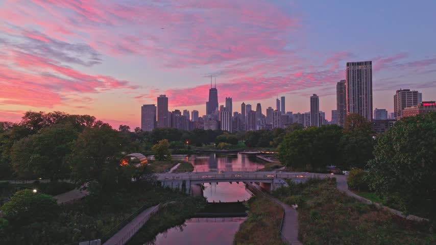 Aerial view over Lincoln Park pond toward Chicago skyline at sunrise