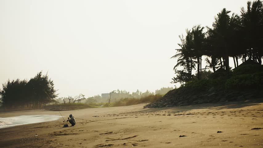 Man riding a motorbike scooter along a hazy tropical beach with palm trees in Bali, Indonesia, travel adventure on the ocean coast