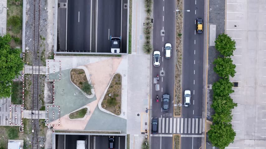 Aerial view of traffic moving along a multi-lane highway with a pedestrian crossing and green spaces in Buenos Aires, Buenos Aires, Argentina.