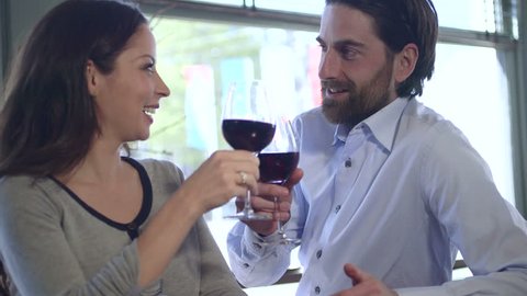 Young couple toasting wine in restaurant