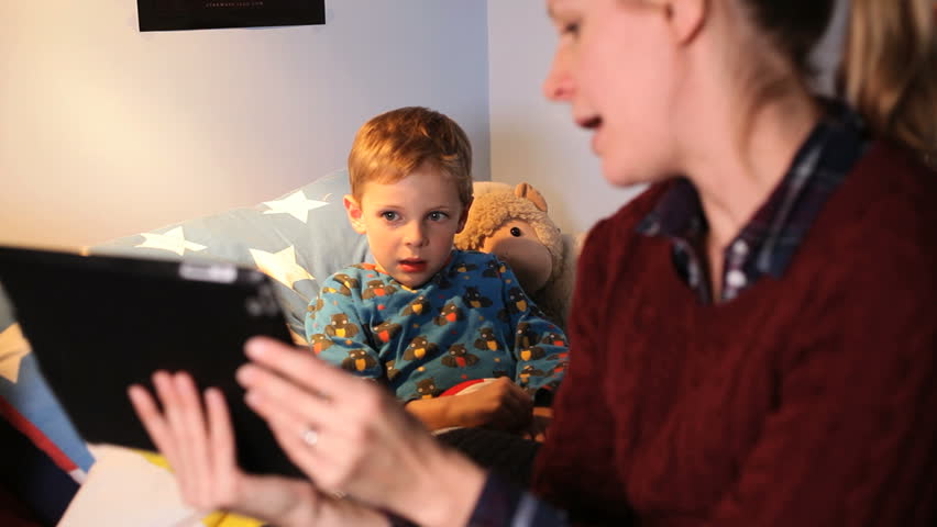 Mother using digital tablet with young boy in bed | Shutterstock HD Video #4213186