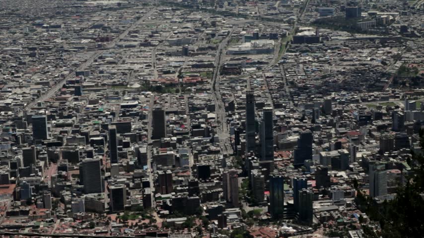 Telephoto view of central Bogotá, Colombia, highlighting high-rise buildings amid the vast urban landscape of the Andean plateau.