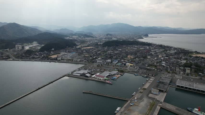 Aerial view of Senzaki harbor and town with layered hazy mountains in the background in Nagato Japan.