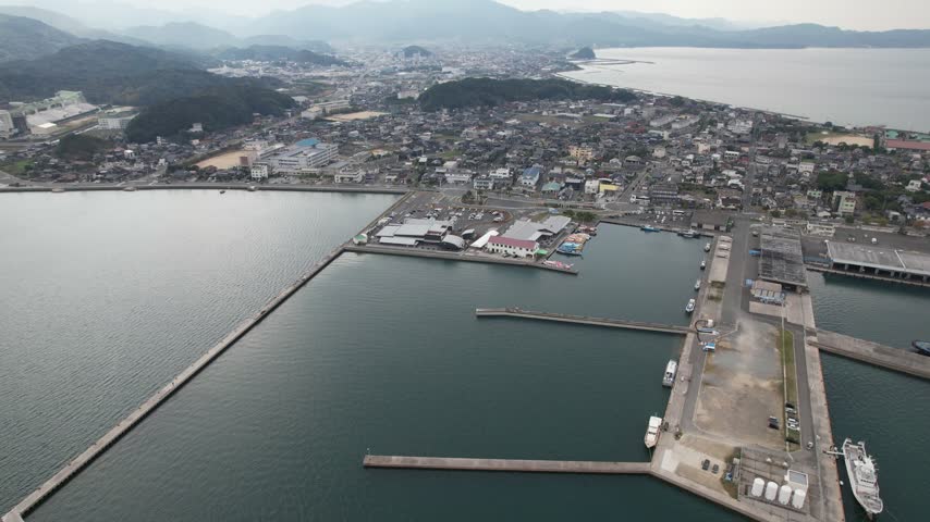 Elevated aerial view of long breakwaters and waterfront buildings at Senzaki harbor in Nagato Japan.