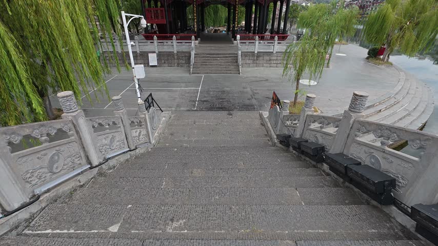 Stone stairway with balustrades leading toward a pavilion gate at Zhenyuan Ancient Town, Guizhou, China.