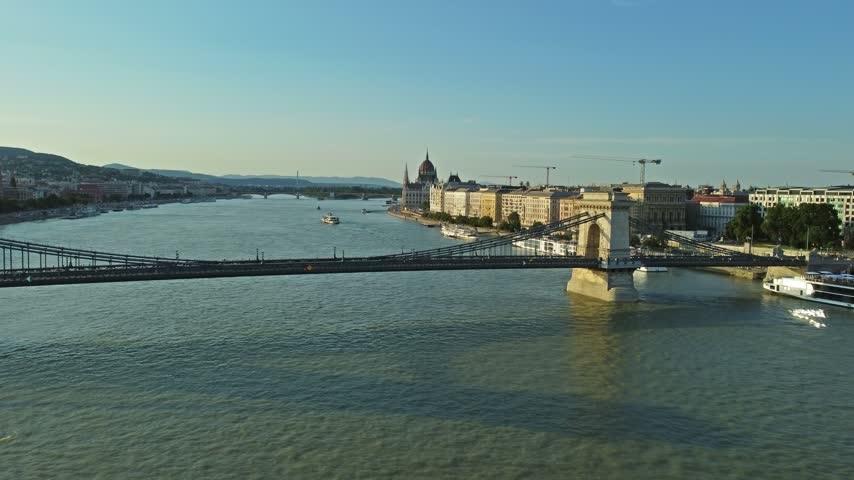 Aerial view of the Szechenyi Chain Bridge spanning the Danube River with the Hungarian Parliament Building in the background in Budapest, Hungary.