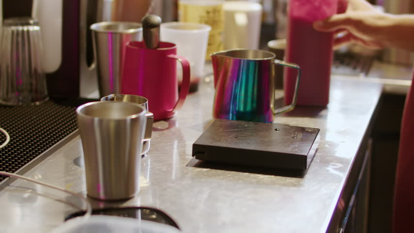 Barista Preparing Drinks in Measuring Cups at Cafe Counter
